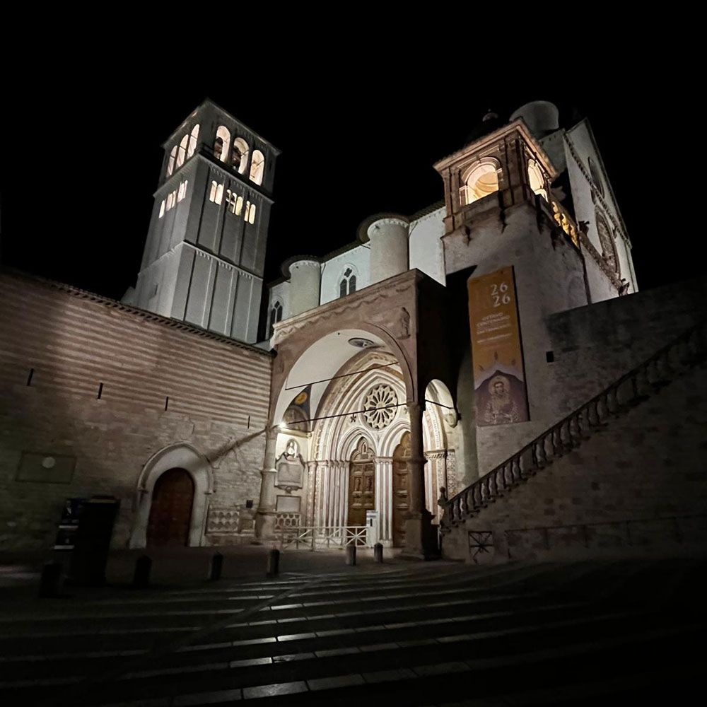 Sulla scalinata della basilica inferiore di Assisi di notte